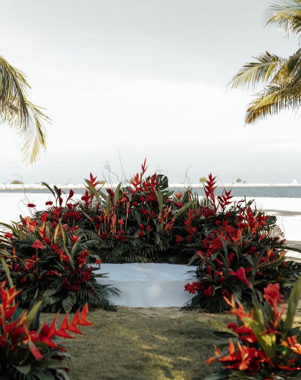Floral set-up of red heliconia and tropical leaves by the lagoon